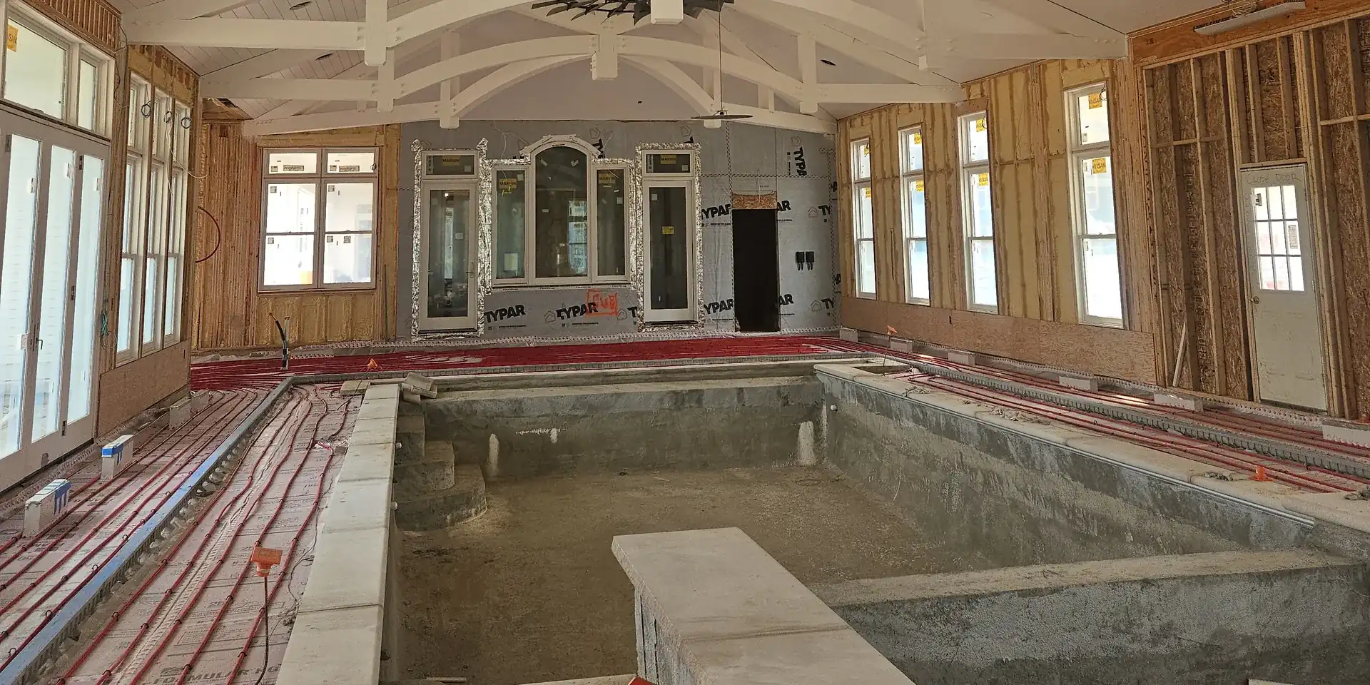 Radiant floor heating installed around an indoor pool in a custom Michigan home