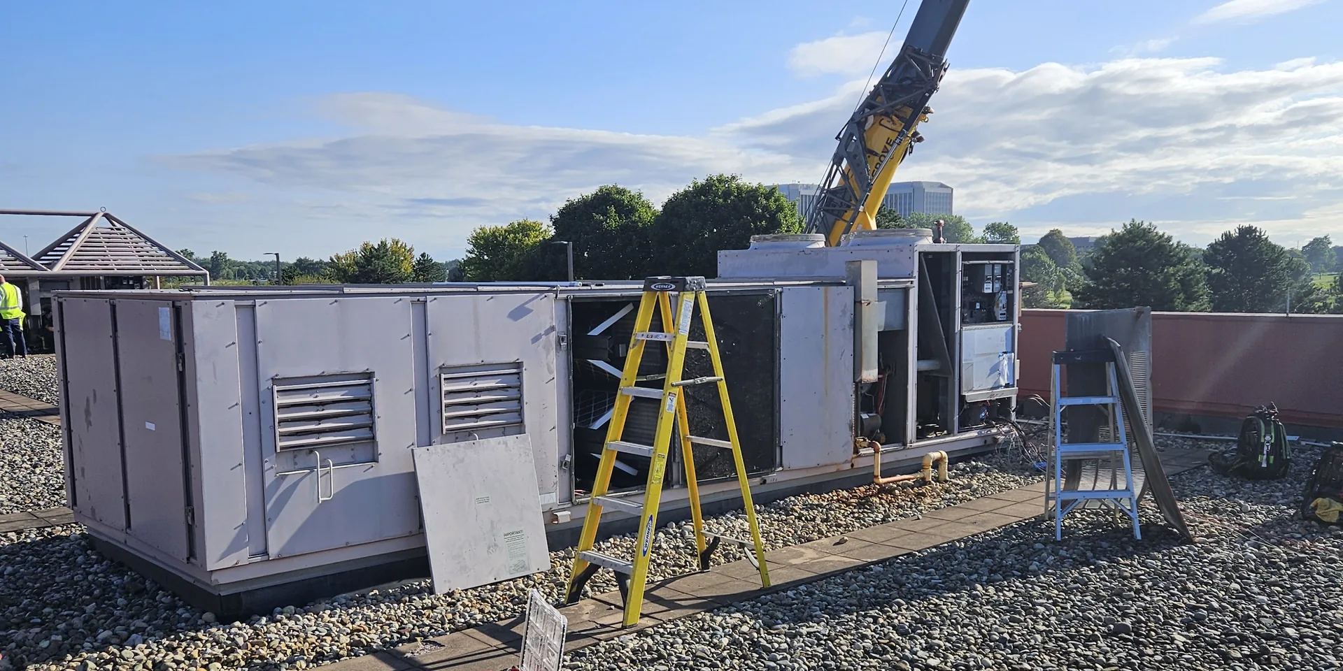 Large commercial rooftop air handling unit being assembled on a commercial building roof
