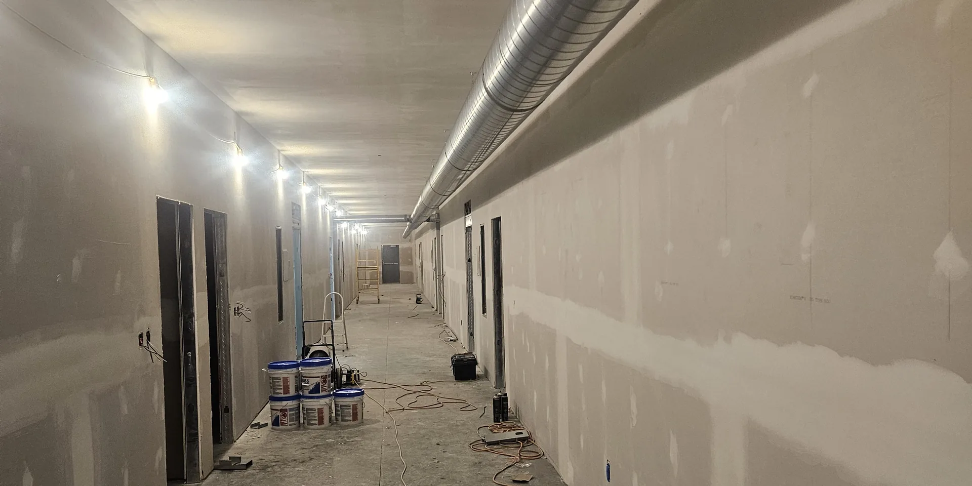 New commercial spiral ductwork installed overhead in a commercial building corridor